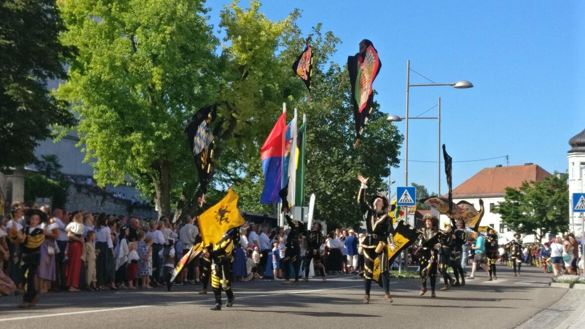 die-fahnenschwinger-des-neuburger-fanfarenzuges-lassen-die-fahnen-durch-die-luft-wirbeln