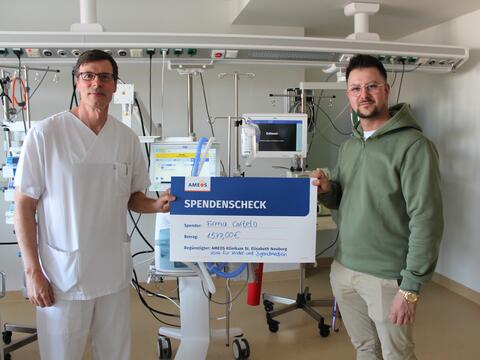 Philipp Rößler von der Firma Cartelo (r.) überreichte den Spendenscheck an Dr. Daniel   
Vilser, Chefarzt der Klinik für Kinder- und Jugendmedizin im AMEOS Klinikum St. Elisabeth   
Neuburg  