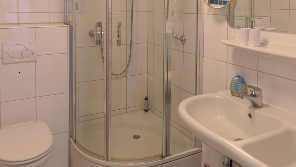 Das helle Bad der Ferienwohnung Johannes verfügt über Dusche, Waschbecken und WC und rundet die komfortable Unterkunft auf Borkum praktisch ab.