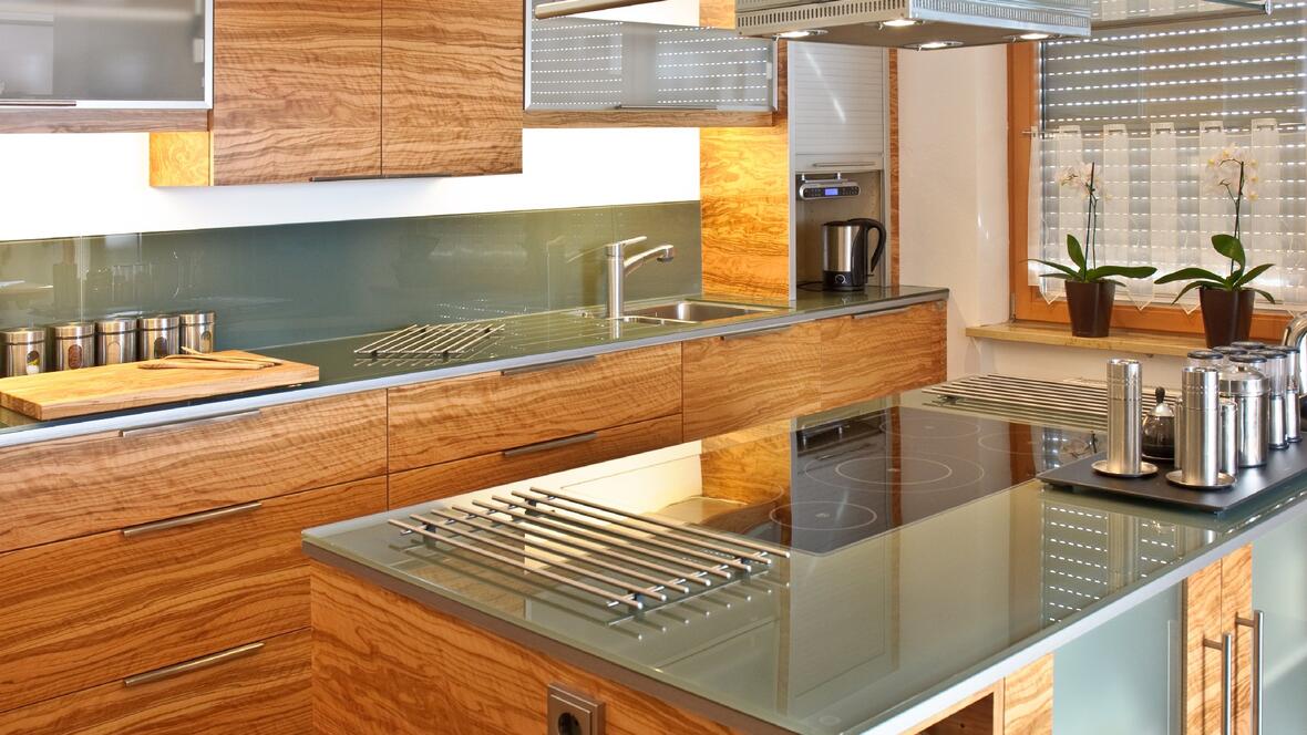 kueche-mit-zentraler-arbeitsplatte-aus-glas-mit-holz-vertaefelt