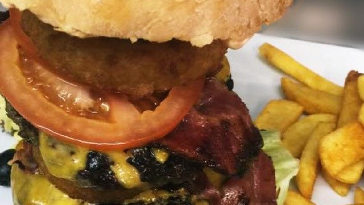 burger-mit-bacon-kaese-tomaten-und-salat-auf-teller